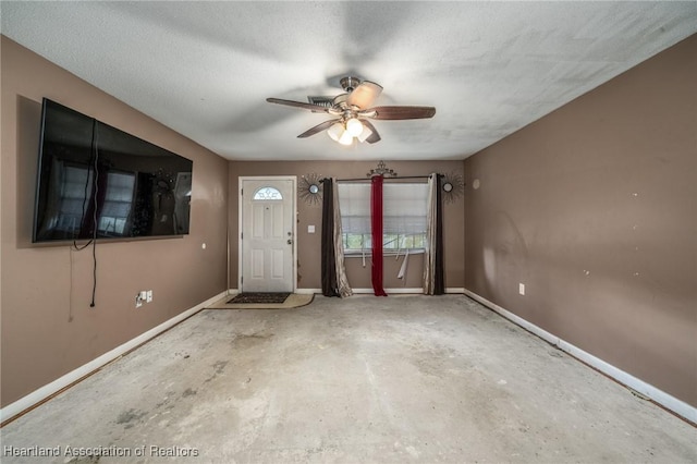 entryway with ceiling fan, concrete flooring, and a textured ceiling