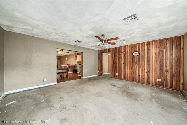 unfurnished room with concrete flooring and wooden walls