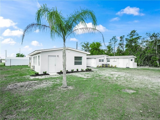 1802 E Claradge Ave, Avon Park, FL 33825 - back of property with stucco siding and a yard