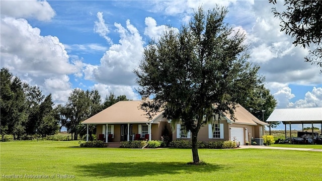 view of front of property featuring covered porch, a carport, a garage, and a front lawn