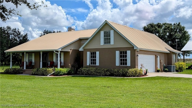 view of front of home featuring central air condition unit, covered porch, a front yard, and a garage