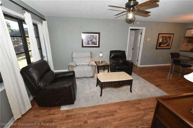 living room with hardwood / wood-style flooring and ceiling fan