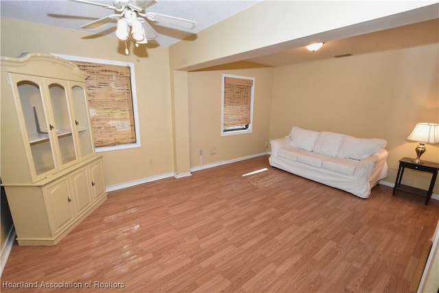 living room featuring ceiling fan and light wood-type flooring