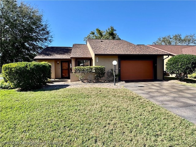 single story home featuring a garage and a front lawn