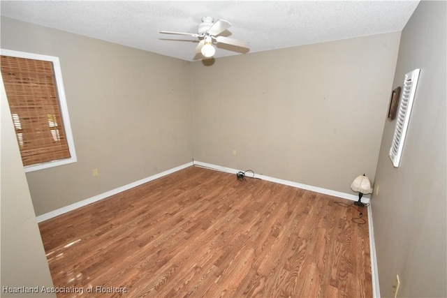 unfurnished room featuring hardwood / wood-style flooring, ceiling fan, and a textured ceiling