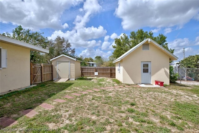 view of yard with an outbuilding, a fenced backyard, and a storage unit