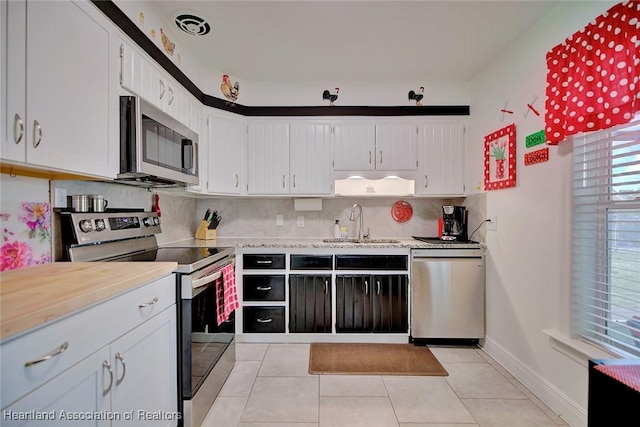 kitchen featuring stainless steel appliances, backsplash, a sink, and light countertops