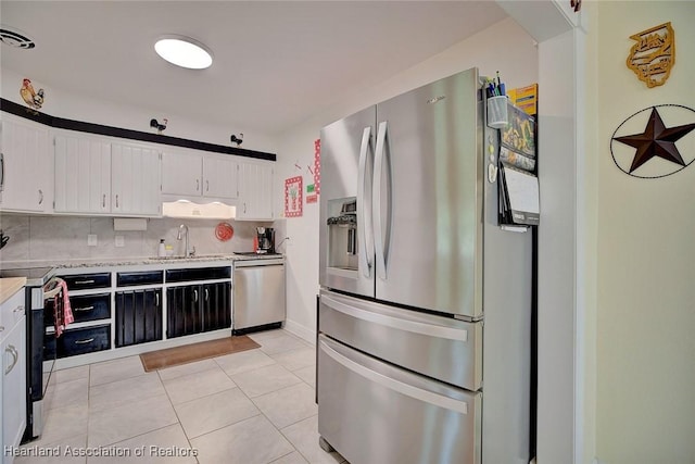 kitchen with a sink, white cabinets, light countertops, appliances with stainless steel finishes, and backsplash