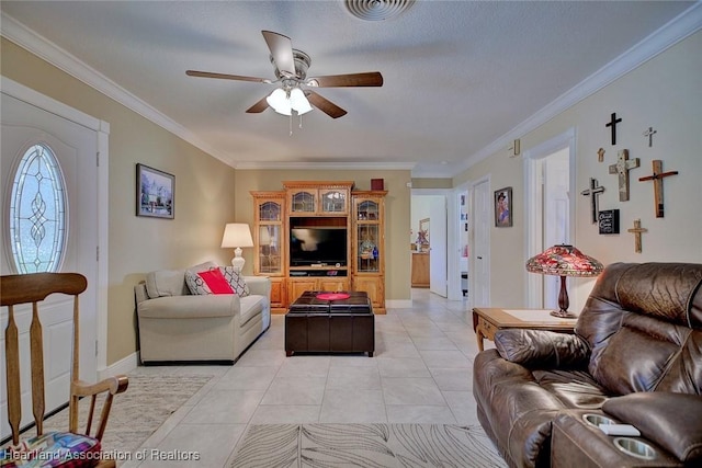 living area featuring ceiling fan, light tile patterned flooring, visible vents, baseboards, and ornamental molding