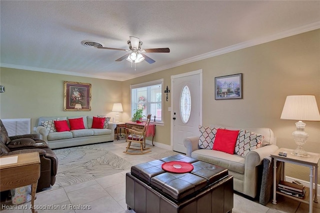 living room with ceiling fan, a textured ceiling, light tile patterned flooring, baseboards, and ornamental molding