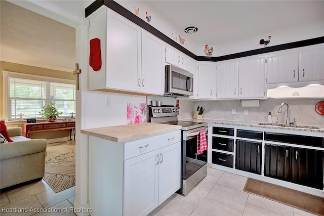 kitchen featuring stainless steel appliances, light countertops, a sink, and light tile patterned floors