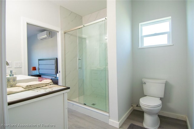 full bathroom with a marble finish shower, toilet, a wall unit AC, and wood finished floors