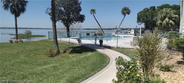 pool featuring a yard, fence, and a water view