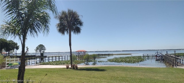 view of dock featuring a yard and a water view