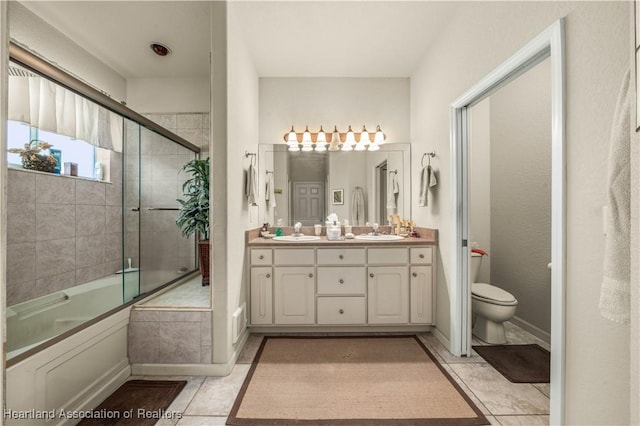 full bathroom featuring tile patterned flooring, toilet, vanity, and combined bath / shower with glass door