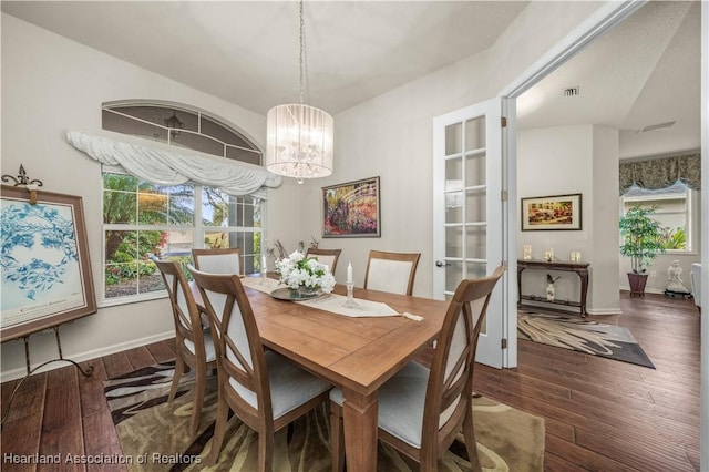 dining space with a chandelier and dark wood-type flooring