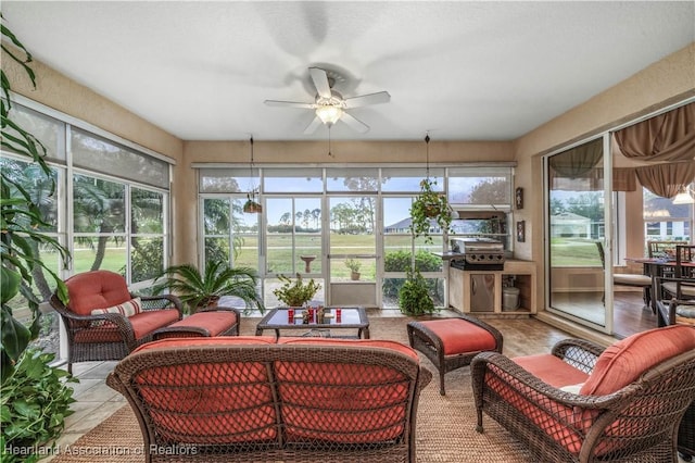 sunroom / solarium featuring ceiling fan