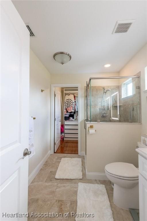 bathroom featuring vanity, toilet, and walk in shower