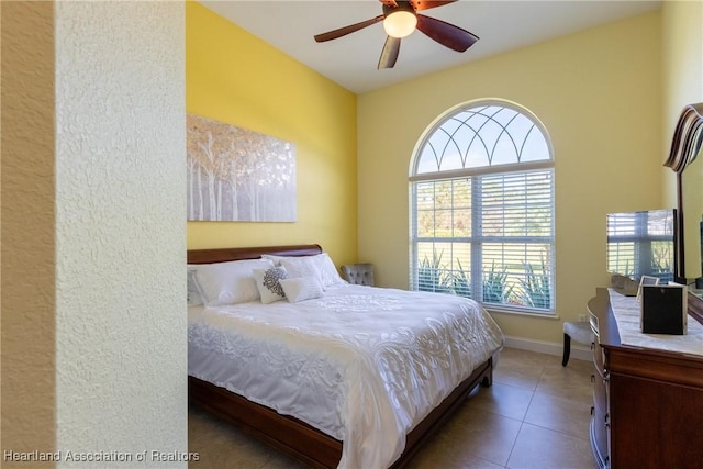 tiled bedroom featuring ceiling fan