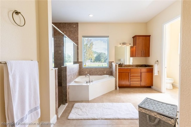 full bathroom with tile patterned floors, separate shower and tub, vanity, and toilet