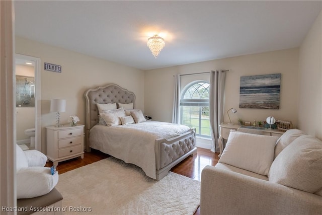 bedroom with dark hardwood / wood-style floors and ensuite bath