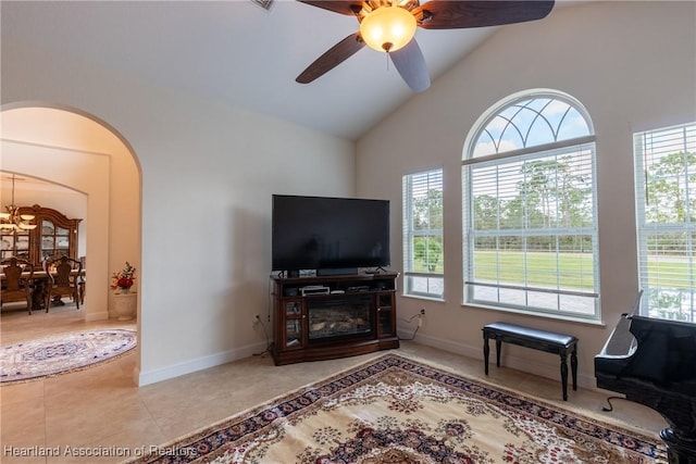 tiled living room with ceiling fan and vaulted ceiling