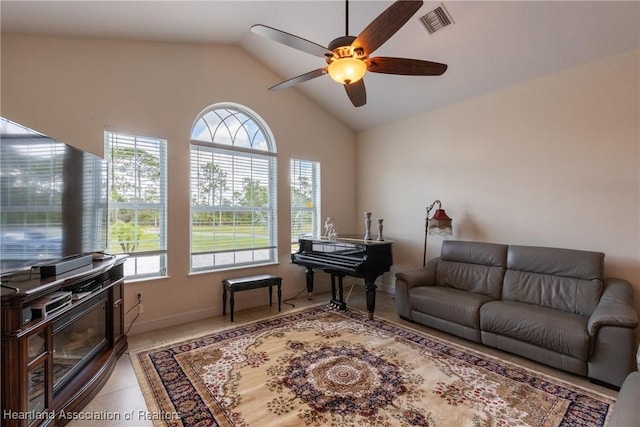 tiled living room with vaulted ceiling, ceiling fan, and a healthy amount of sunlight