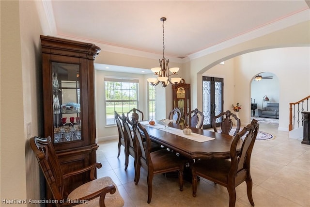 dining space featuring light tile patterned floors, ceiling fan with notable chandelier, and ornamental molding