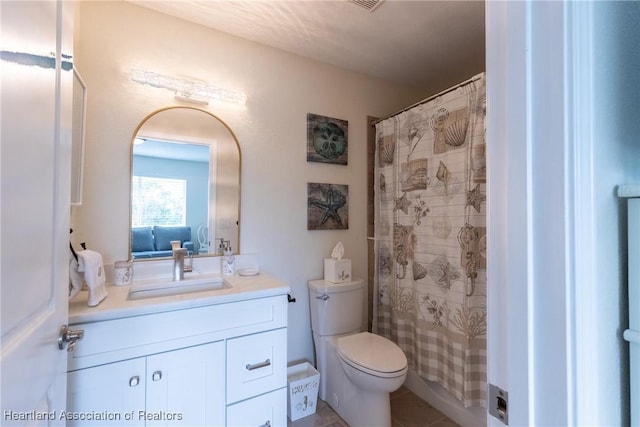 bathroom with vanity, toilet, and curtained shower