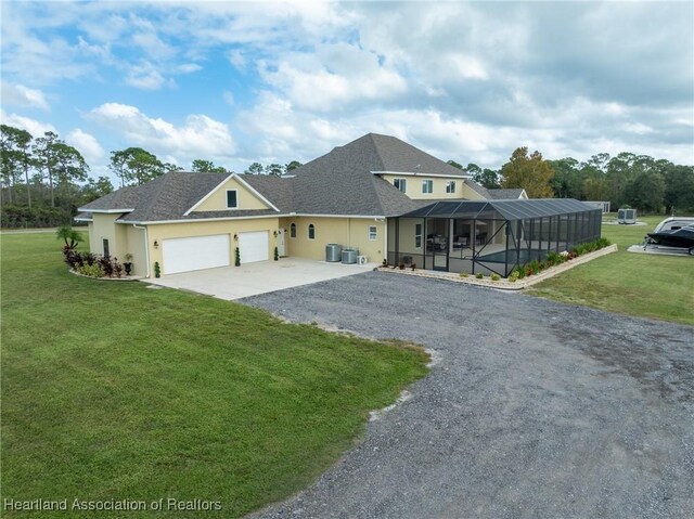 view of front of house with a front yard, a garage, and a lanai