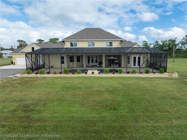 rear view of house with a lanai and a lawn