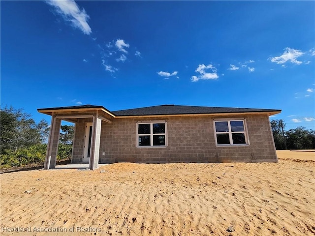 rear view of house with concrete block siding