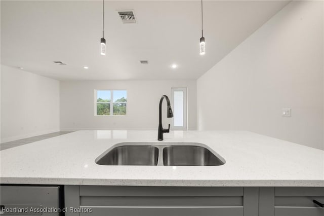 kitchen featuring a sink, gray cabinetry, open floor plan, hanging light fixtures, and recessed lighting