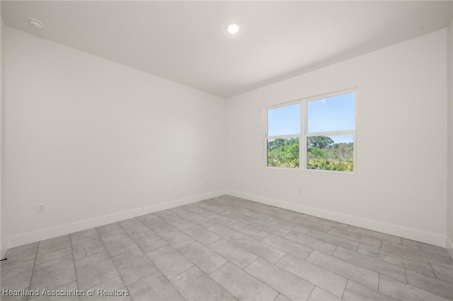 unfurnished room with baseboards and recessed lighting