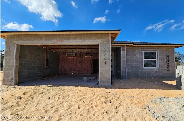 view of front of home featuring a garage and concrete block siding