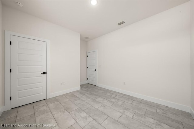 spare room with a smoke detector, baseboards, and recessed lighting