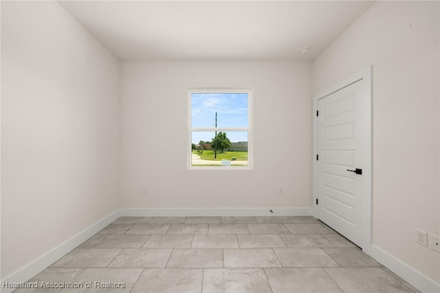 empty room with baseboards and a smoke detector