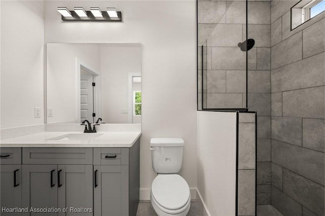bathroom with walk in shower, vanity, toilet, and baseboards