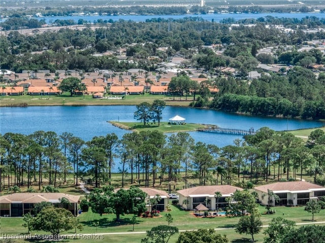 aerial view of residential area with a nearby body of water and a tree filled landscape