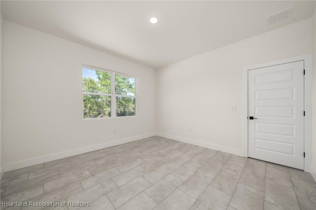 spare room featuring baseboards and recessed lighting