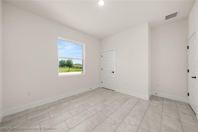 spare room featuring baseboards and recessed lighting