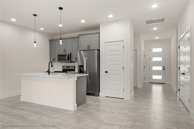 kitchen with appliances with stainless steel finishes, gray cabinets, light countertops, recessed lighting, and baseboards