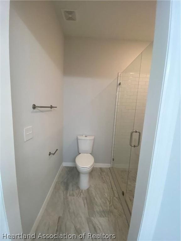 bathroom featuring toilet and walk in shower