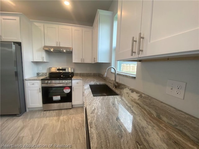 kitchen featuring white cabinets, stainless steel appliances, light stone countertops, and sink