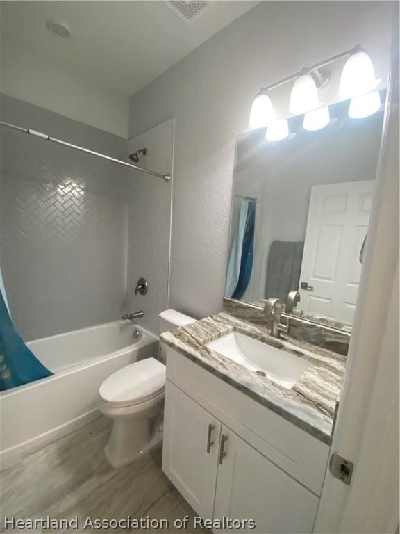 full bathroom featuring vanity, shower / tub combo, and toilet