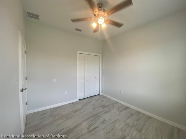 unfurnished bedroom featuring ceiling fan and a closet