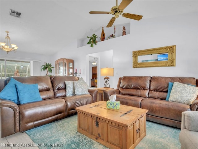 living room with ceiling fan with notable chandelier and high vaulted ceiling