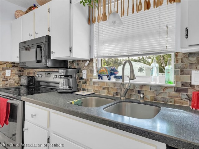 kitchen with electric stove, backsplash, sink, and white cabinets