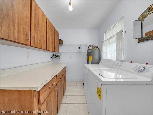 laundry room featuring separate washer and dryer, cabinets, water heater, and light tile patterned flooring