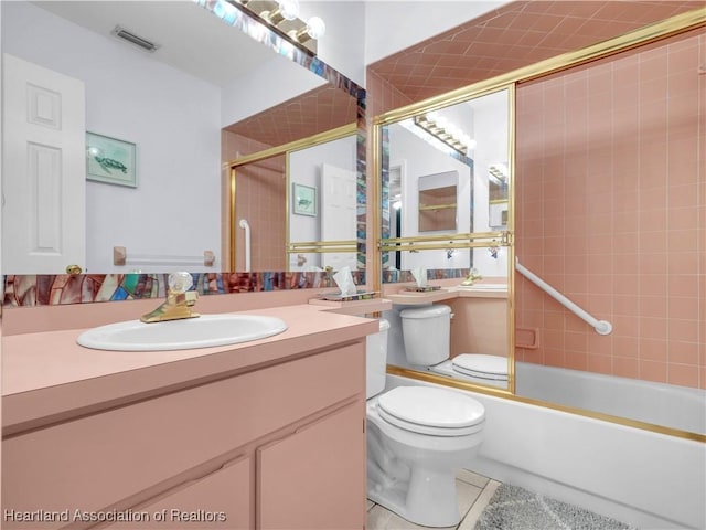 full bathroom with vanity, bath / shower combo with glass door, tile patterned floors, and toilet